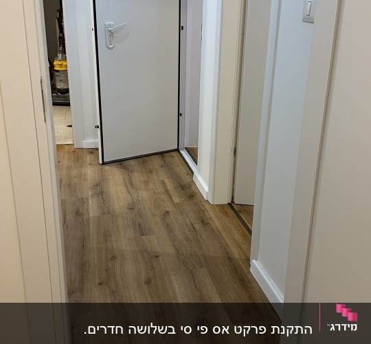 רצפת פרקט במסדרון עם דלתות לבנות